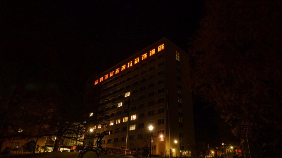 Bild des Hauptgebäudes der Bezirksregierung mit orange erleuchtetem 10. Stock