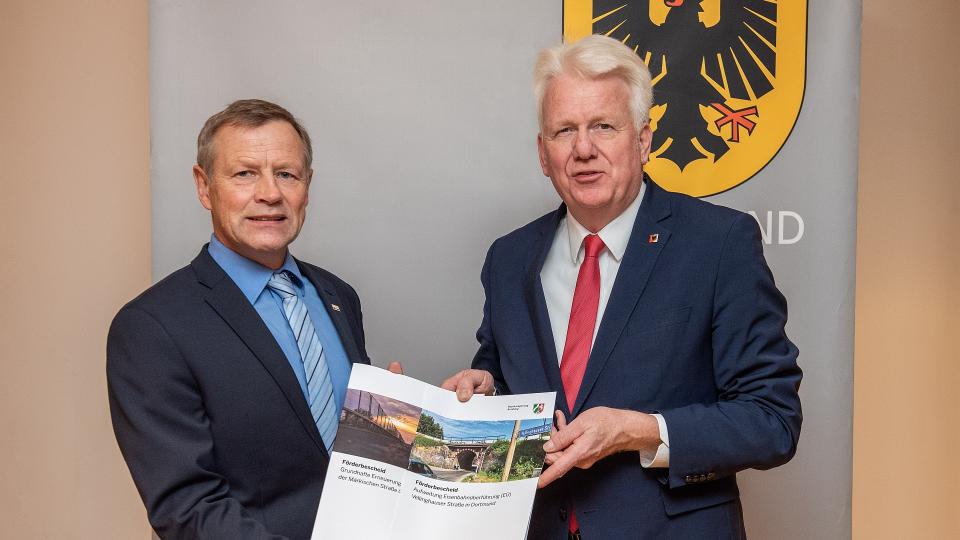 Regierungsvizepräsident Volker Milk (links) übergibt zwei Förderbescheide an den Dortmunder Oberbürgermeister Ullrich Sierau