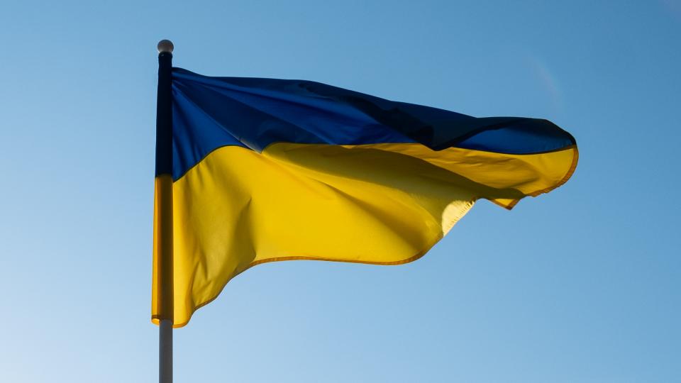Die ukrainische Flagge vor blauem Himmel.
