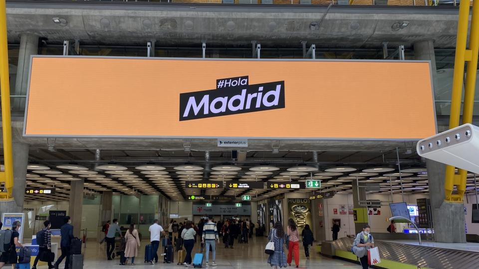Das Bild zeigt ein „Hola Madrid“ Schild am Flughafen Madrid. 