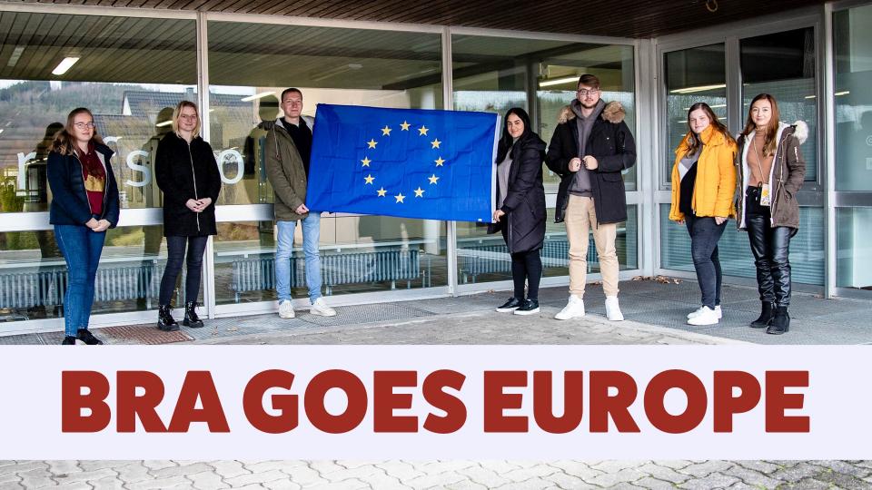 as Bild zeigt sieben Auszubildende mit einer Europa-Flagge vor der Abreise nach Spanien. Im unteren Bereich des Bildes steht der Schriftzug „BRA GOES EUROPE“.