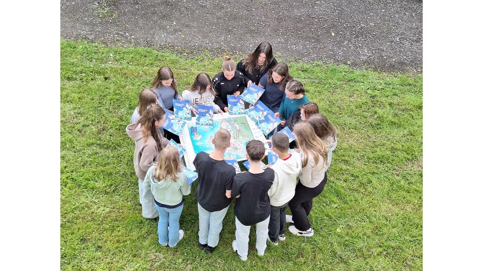 Abgebildet sind mehrere Kinder, die auf eine Europakarte blicken. 