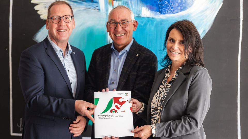 Hubertus Winterberg (Geschäftsführer der Südwestfalen Agentur GmbH (links)) nahm stellvertretend für den Kreis Olpe den Förderbescheid von Regierungspräsident Heinrich Böckelühr (Mitte) und Claudia Vielhaber (Bezirksregierung Arnsberg) entgegen.