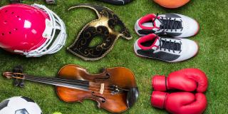 Abgebildet sind Sportgeräte und Sportkleidung aus unterschiedlichsten Sportarten. Darüber hinaus sind auch noch Gegenstände aus Kunst und Kultur abgebildet, wie z. B. eine Violine und eine venezianische Maske.