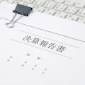 Ein zusammengeheftetes Schriftstück mit aufgedruckten ostasiatischen Zeichen liegt auf einer Tastatur. 