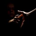 Eine Frau nimmt die ausgestreckte Hand einer anderen Person an. Die Frau befindet sich in sehr dunkler Umgebung, sodass sie kaum zu erkennen ist. 